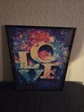 LOVE diamond painting with colorful background displayed in a black frame