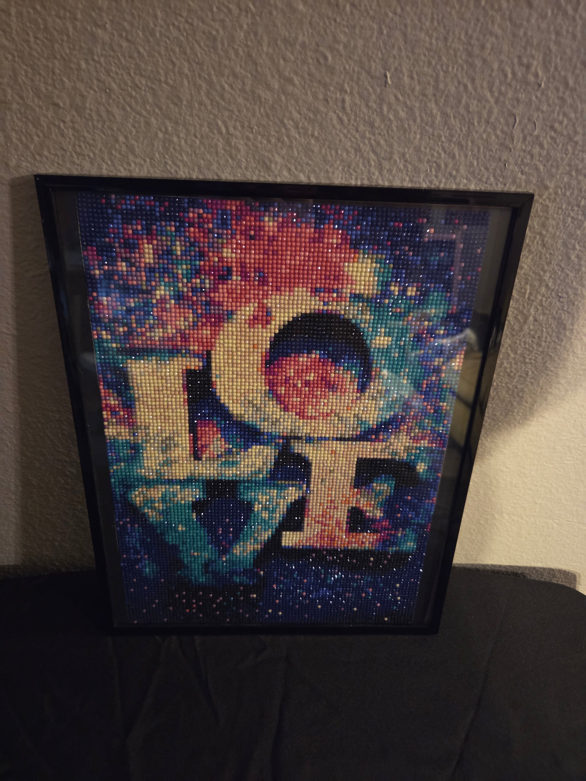 LOVE diamond painting with colorful background displayed in a black frame