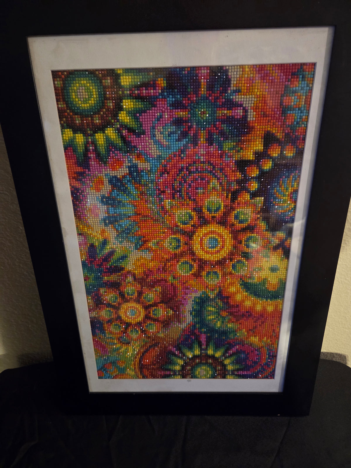 Colorful abstract floral diamond painting with a white mat and black frame