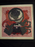 Baby Venom diamond painting against a pink background, displayed in a black frame with a white mat