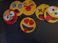 Six round diamond art emoticon coasters with colorful expressive faces, displayed with a black holder.